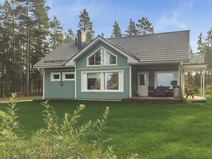 A two-story house with a covered porch and a well-maintained lawn.