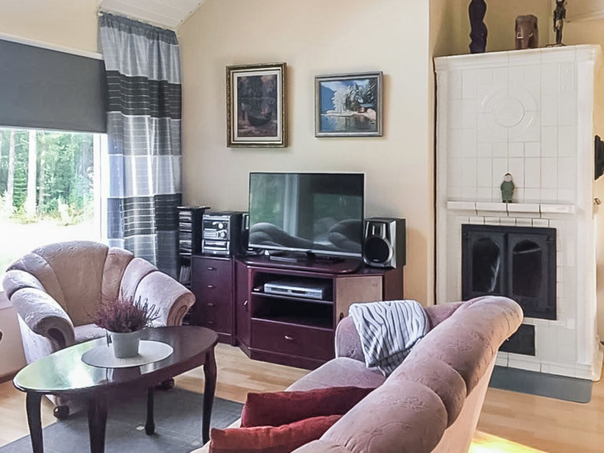 A living room with a sofa, a coffee table, a TV, and a fireplace.