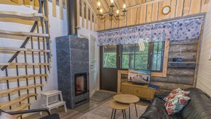 A cozy cabin interior with a fireplace, a sofa, a TV, and a wooden staircase. - Kantapää d2 by Interhome (Sodankylä)