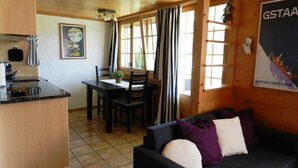 A cozy cabin interior with a dining area, a kitchen, and a living room. - Bijou Arnensee by Interhome (Feutersoey)