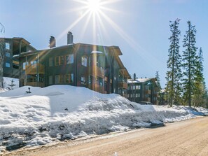 Un edificio de varios pisos con suelo cubierto de nieve y cielo despejado.