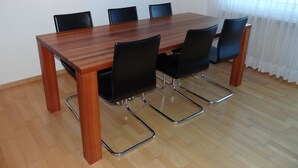 Ein Konferenzraum mit einem Holztisch und schwarzen Stühlen.