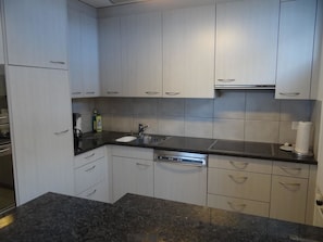 A kitchen with white cabinets, a stainless steel sink, and a dishwasher. - Dorfstrasse 15 Appartement/Fewo 7-Bettwohnung by Interhome (Engelberg)