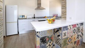 A modern kitchen with a white countertop, a built-in oven, a microwave, and a stainless steel range hood. - Apartment Primun by Interhome (Calpe/Calp)