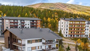 A modern multi-story building with balconies, situated in a mountainous area with autumn foliage. - Villa ylläs 203 by Interhome (Ylläsjärvi)