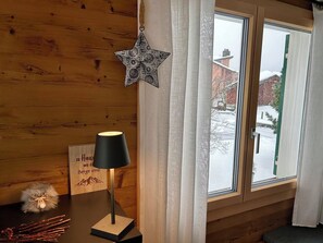 A wooden interior with a window, a lamp, and a star decoration. - Chalet Fluegärtli Appartement/Fewo 6-Bettwohnung by Interhome (Engelberg)