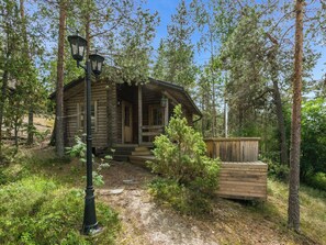 A rustic cabin with a porch, surrounded by trees and a wooden deck. - Elimäki by Interhome (Pöytyä)