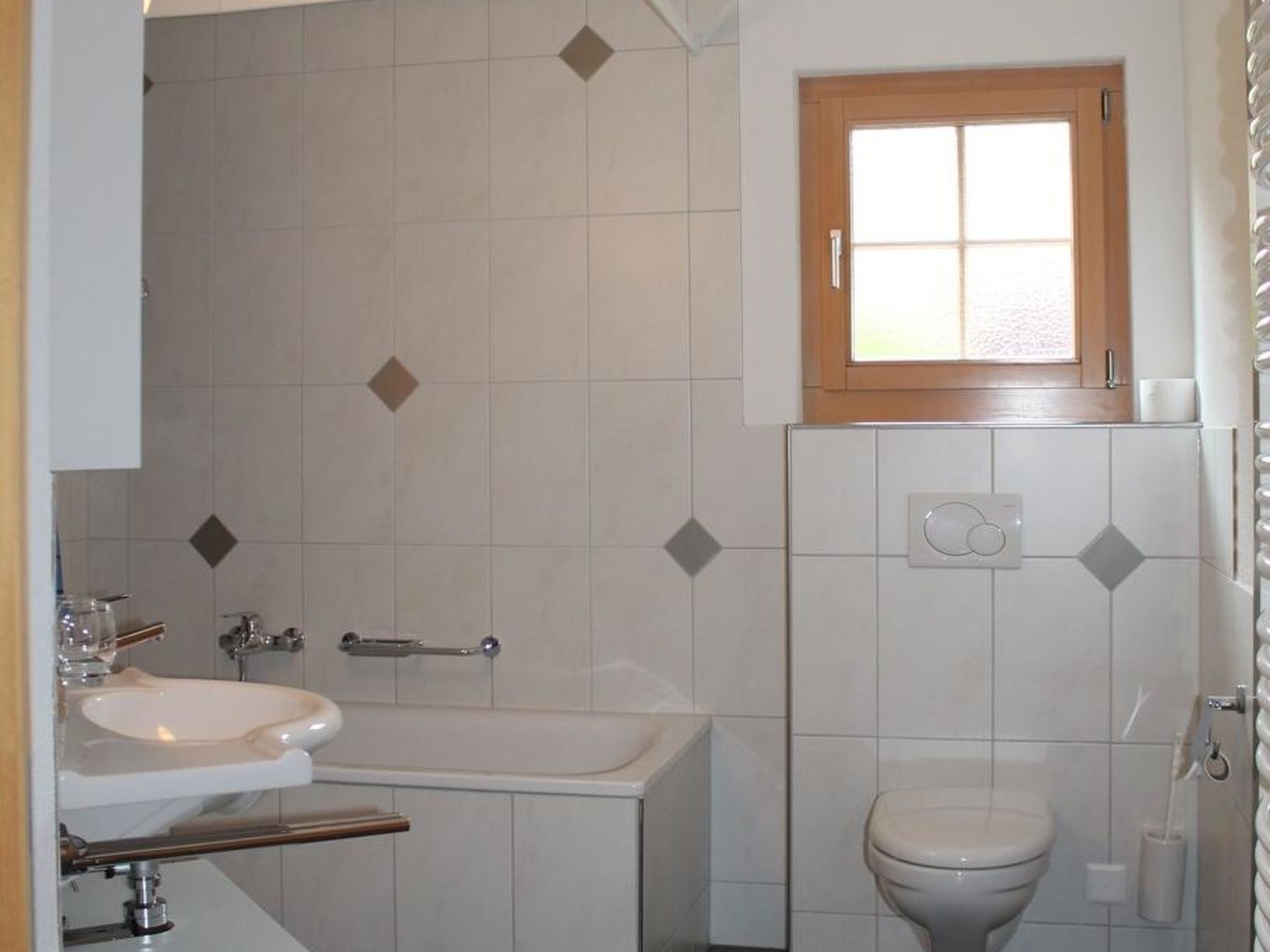 Un baño con lavamanos, bañera y retrete.