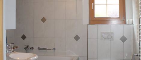 Un baño con lavamanos, bañera y retrete.