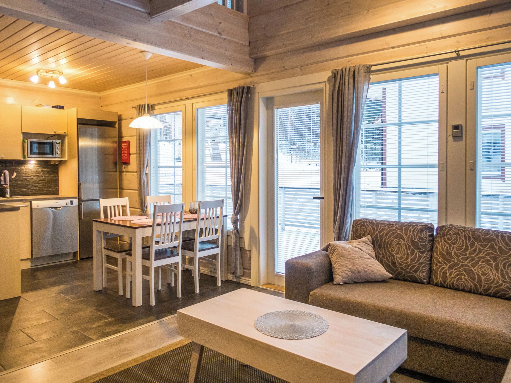 A modern interior with a dining area, sofa, and kitchen.
