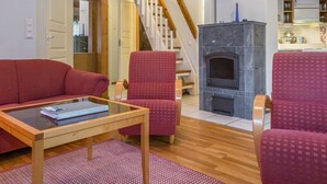 Una sala de estar con un sofá rojo, una mesa de centro de cristal y una chimenea.
