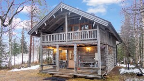 A rustic cabin with a wooden exterior, a balcony, and a porch with seating. - Vacation home Varsta by Interhome (Kuusamo)