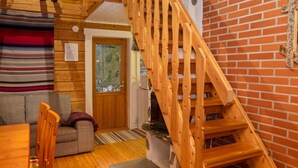 A wooden interior with a staircase, a sofa, and a dining table. - Vacation home Varsta by Interhome (Kuusamo)