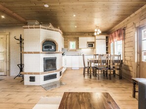 Una cocina amplia con horno empotrado, un comedor con sillas de madera y una chimenea.