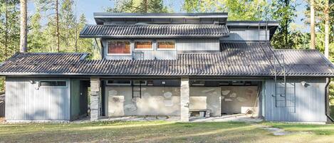 Un bâtiment à deux étages, doté d’un toit en pente, de fondations en pierre et d’un garage.