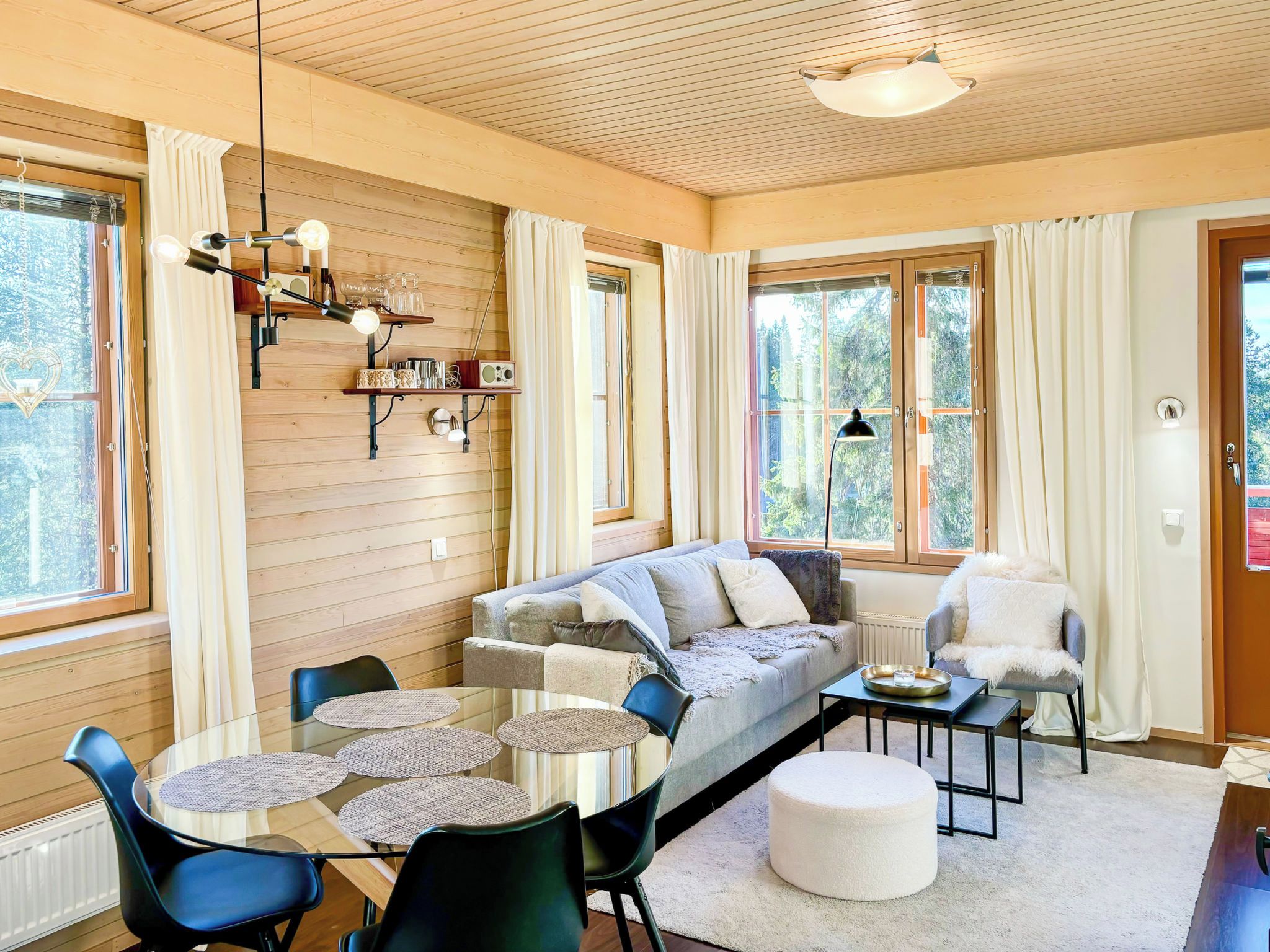 A cozy living room with a sofa, chairs, a coffee table, and a dining table.