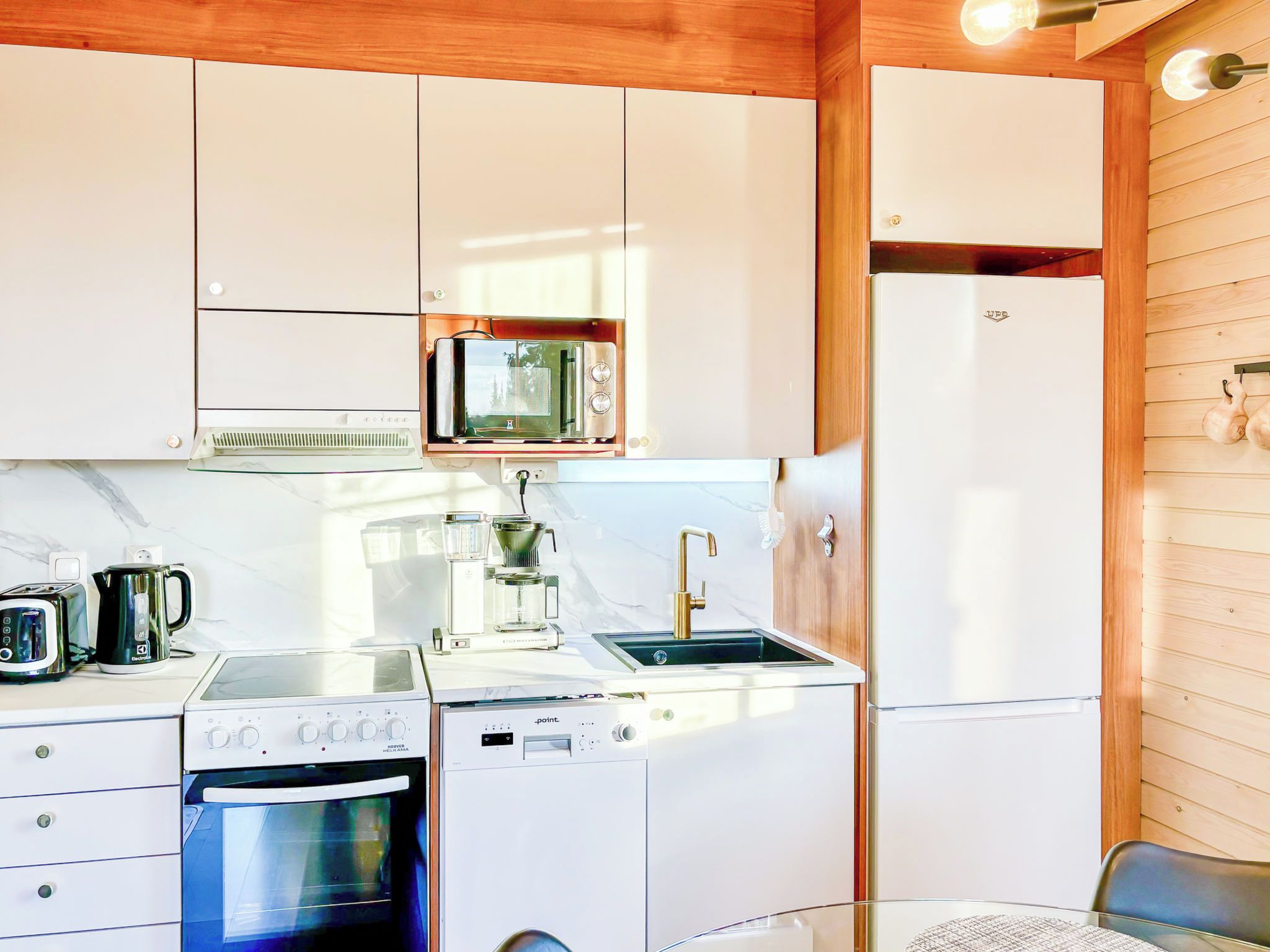 A compact kitchen with a microwave, stove, oven, and refrigerator.