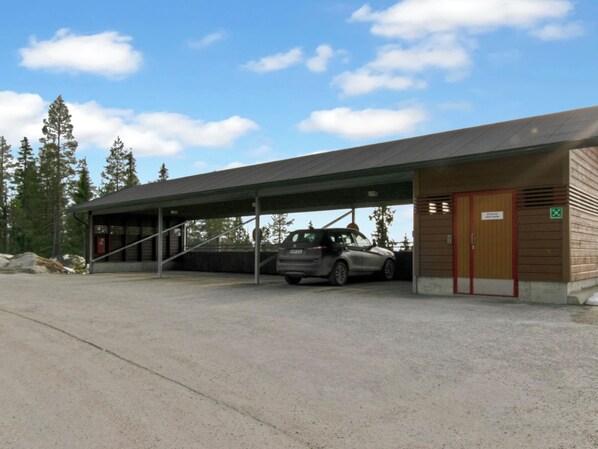 A building with a covered parking area and a car parked inside.