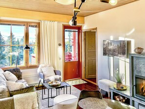 A cozy living room with a fireplace, a sofa set, a coffee table, and a television.