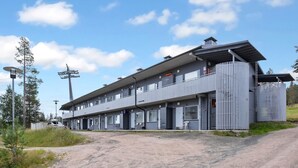 A modern two-story building with a flat roof and a balcony on the upper floor. - Snowflake b 24 by Interhome (Kuusamo)