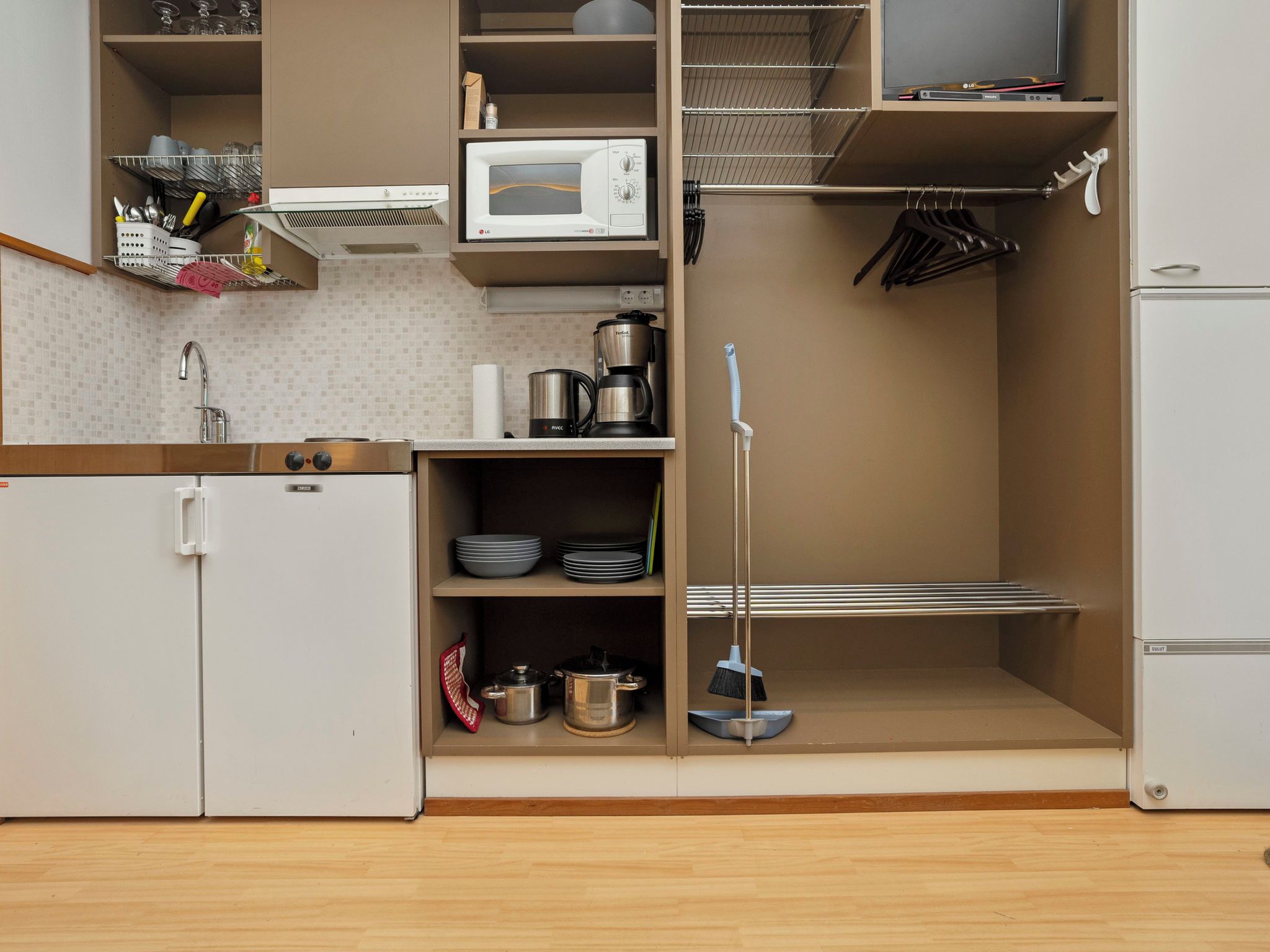 A compact kitchen with a microwave, stove, and refrigerator.