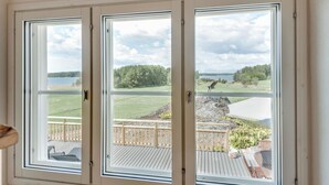 Ett rum med ett stort fönster med utsikt över en terrass och en sjö.
