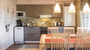 A modern kitchen with wooden cabinets, a microwave, and a dining area with a table and chairs.
