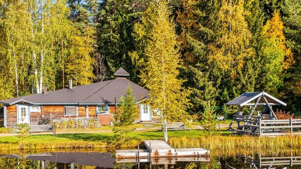 A cabin with a dock extending into a calm lake, surrounded by dense forest. - Kuusenkatve by Interhome (Nilsiä)