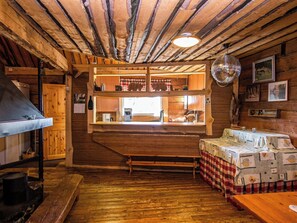 A rustic wooden interior with a bar area, wooden beams on the ceiling, and a disco ball. - Kuusenkatve by Interhome (Nilsiä)