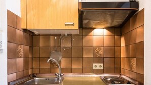 A kitchen with wooden cabinets, a stainless steel sink, and a built-in stove. - Birke (A504) by Interhome (Lahnstein (Koblenz))