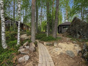 Une zone boisée avec un sentier en pierre menant à un chalet.