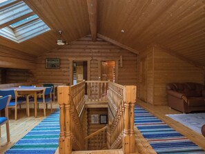 Un intérieur en bois comprenant un escalier, un coin repas et un salon.