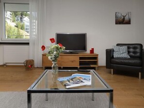 Relax in this stylish living room with a comfortable sofa, flat-screen TV, and a coffee table.