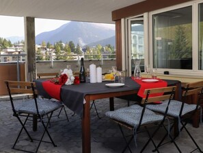 Enjoy meals with a scenic view from this dining area, featuring a table set for four with comfortable seating and elegant table settings.