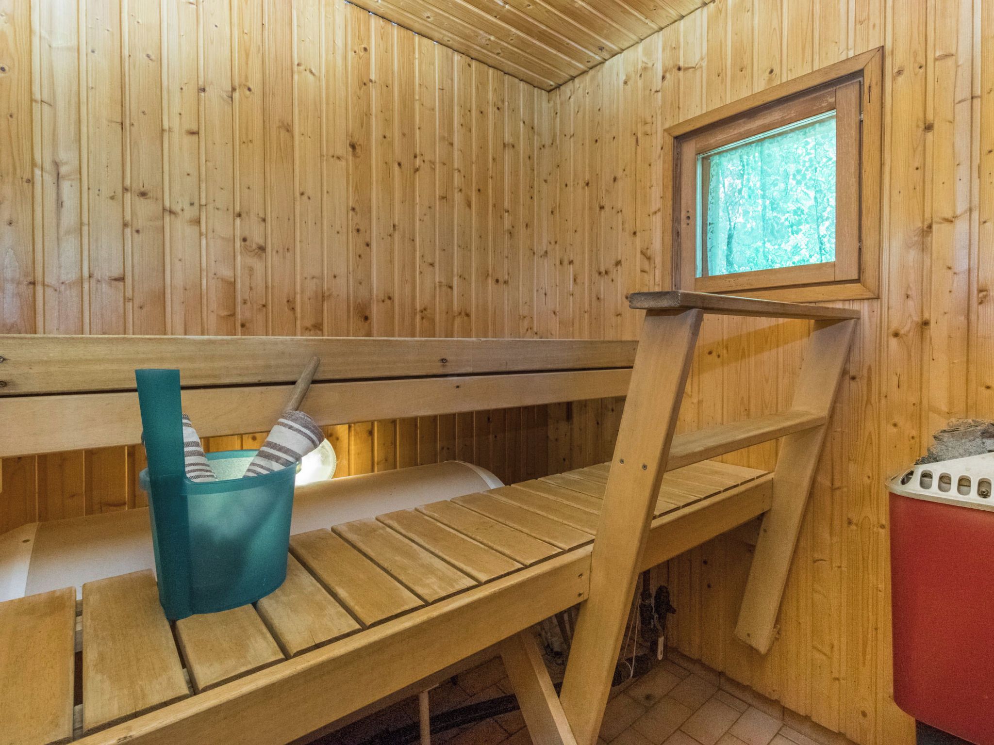 Eine Holzsauna mit Bänken und einem Fenster.