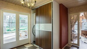 A room with a checkered floor, a sliding door, and a view of a forest through the windows. - Ylläs siesta by Interhome (Ylläsjärvi)