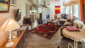 A cozy living room with a fireplace, a television, and a dining area with a table and chairs. - Ylläs siesta by Interhome (Ylläsjärvi)