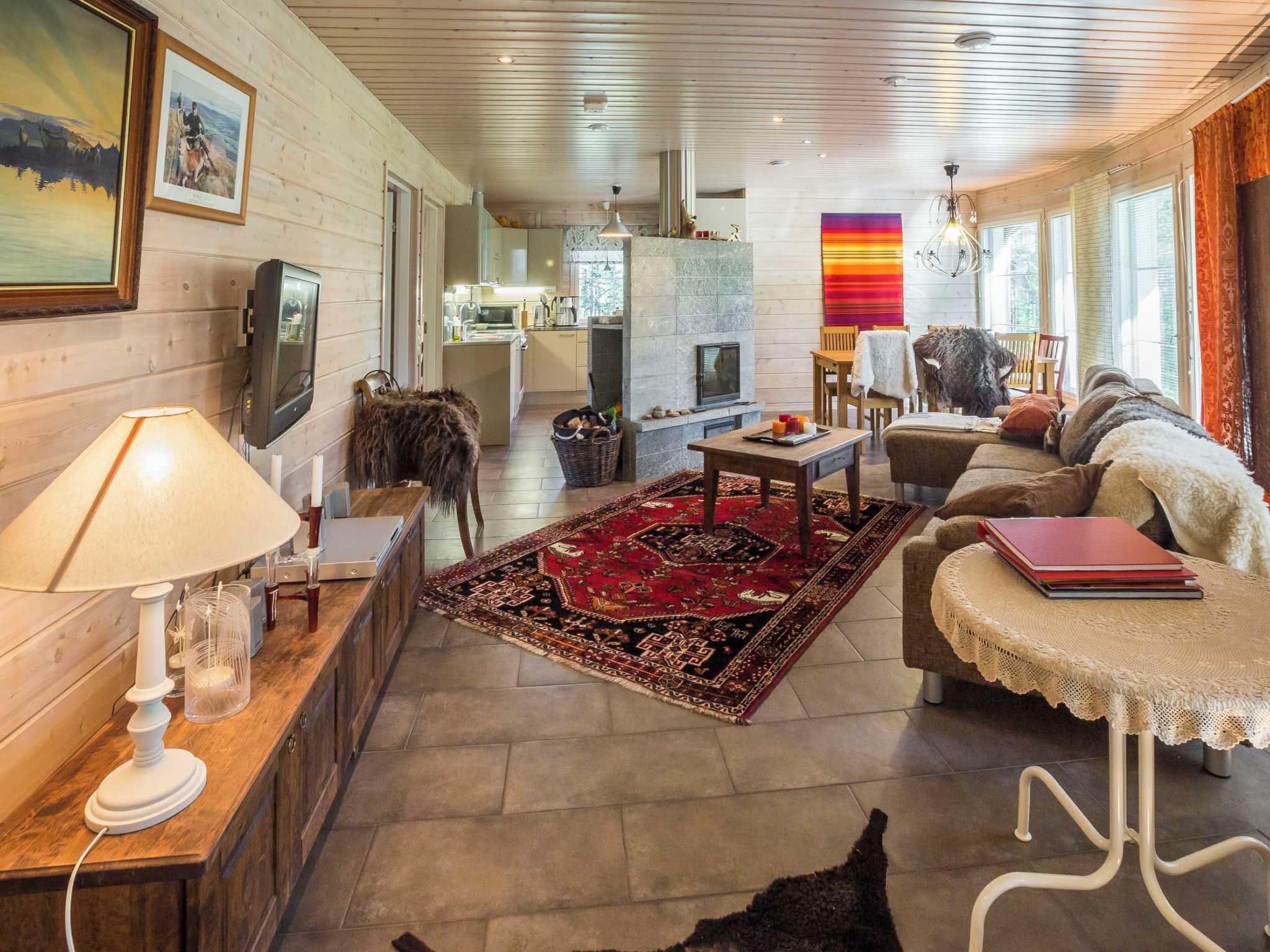 A cozy living room with a fireplace, a dining area, and a kitchen in the background.
