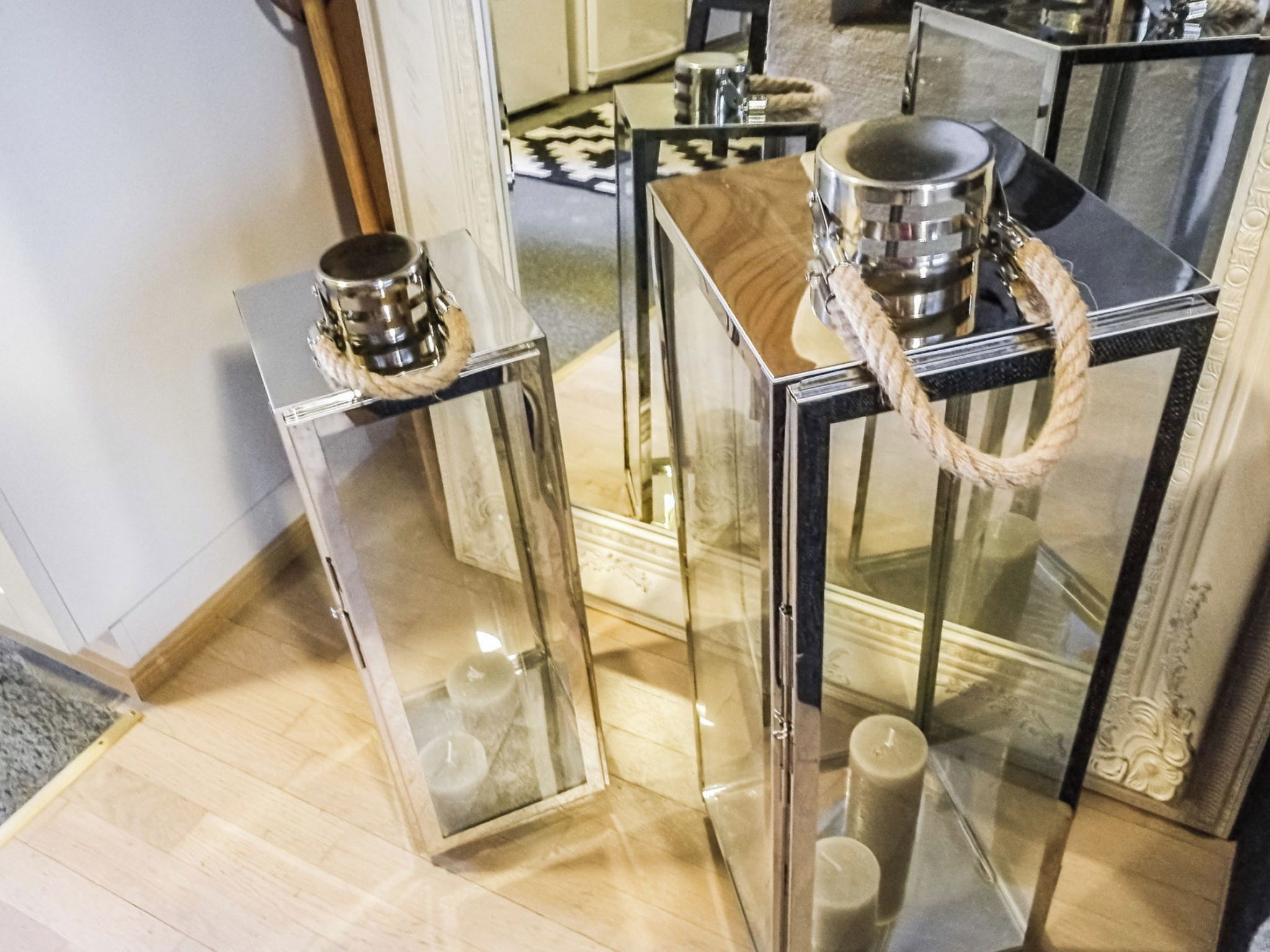 Zwei Glastische mit Metallfüßen, einer mit Seilgriff und der andere mit einem Topf darauf.