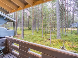 A wooden deck with a view of a forested area.
