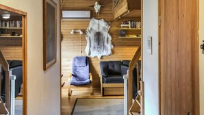 A room with wooden walls, a fur rug, a bookshelf, and two chairs. - Soidinaukea b 20 by Interhome (Inari)