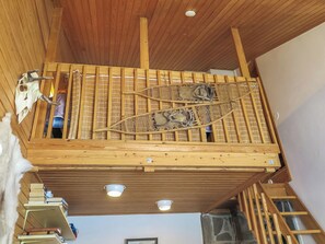 Une chambre à coucher aménagée dans les combles, avec un plafond en pente, une lucarne et une vue sur le ciel.