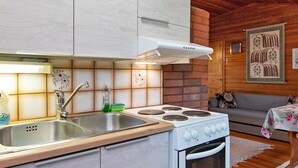 Una cucina moderna con lavello in acciaio inossidabile, piano cottura e cappa aspirante bianca.