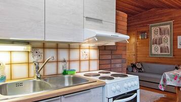 A kitchen with a stove, sink, and cabinets.