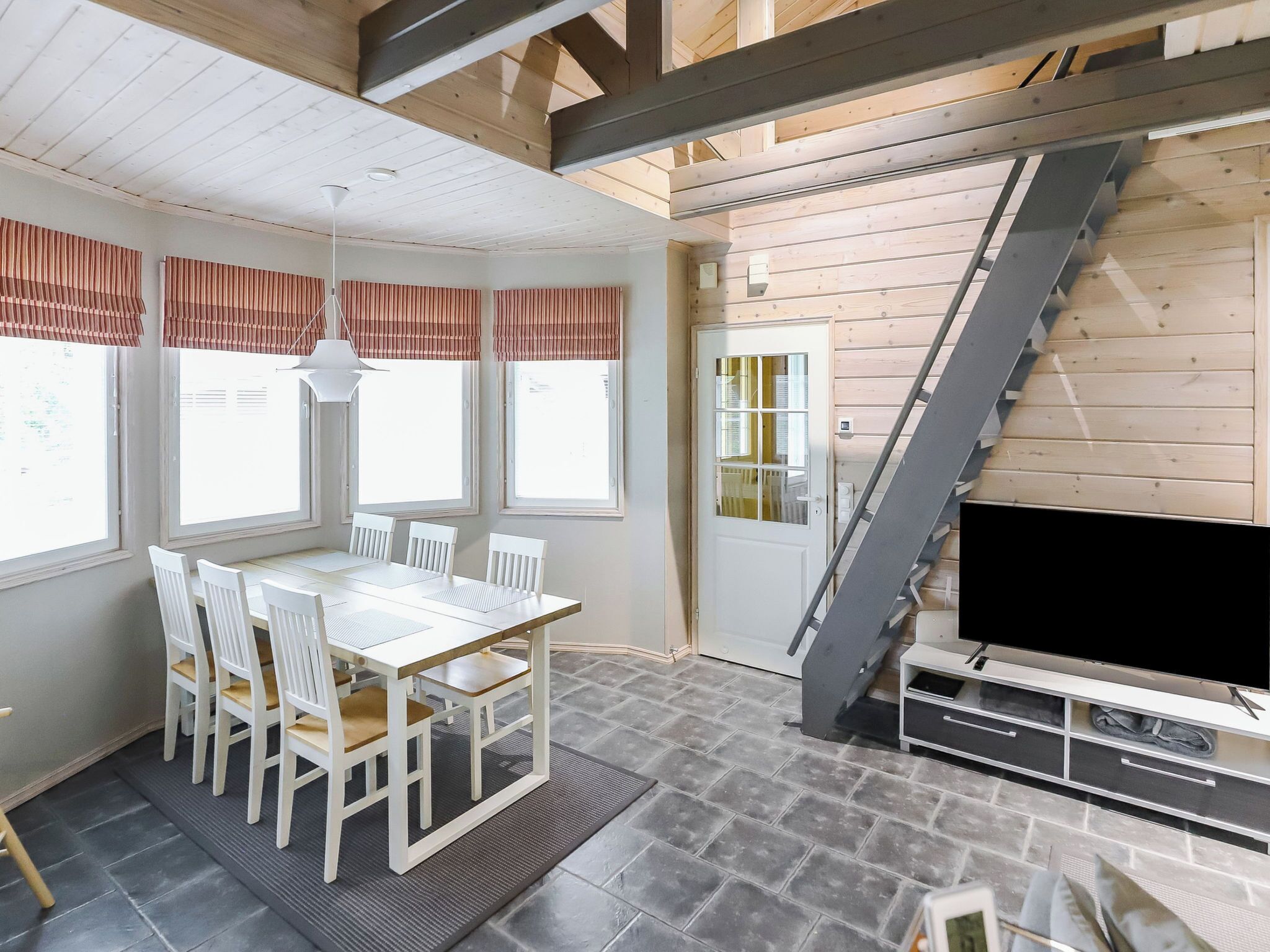 A modern kitchen with a large island, a built-in oven, and a stainless steel sink.