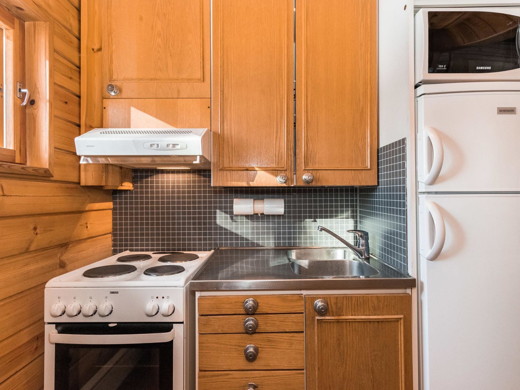 Een koelkast, een magnetron, kookgerei, borden en bestek