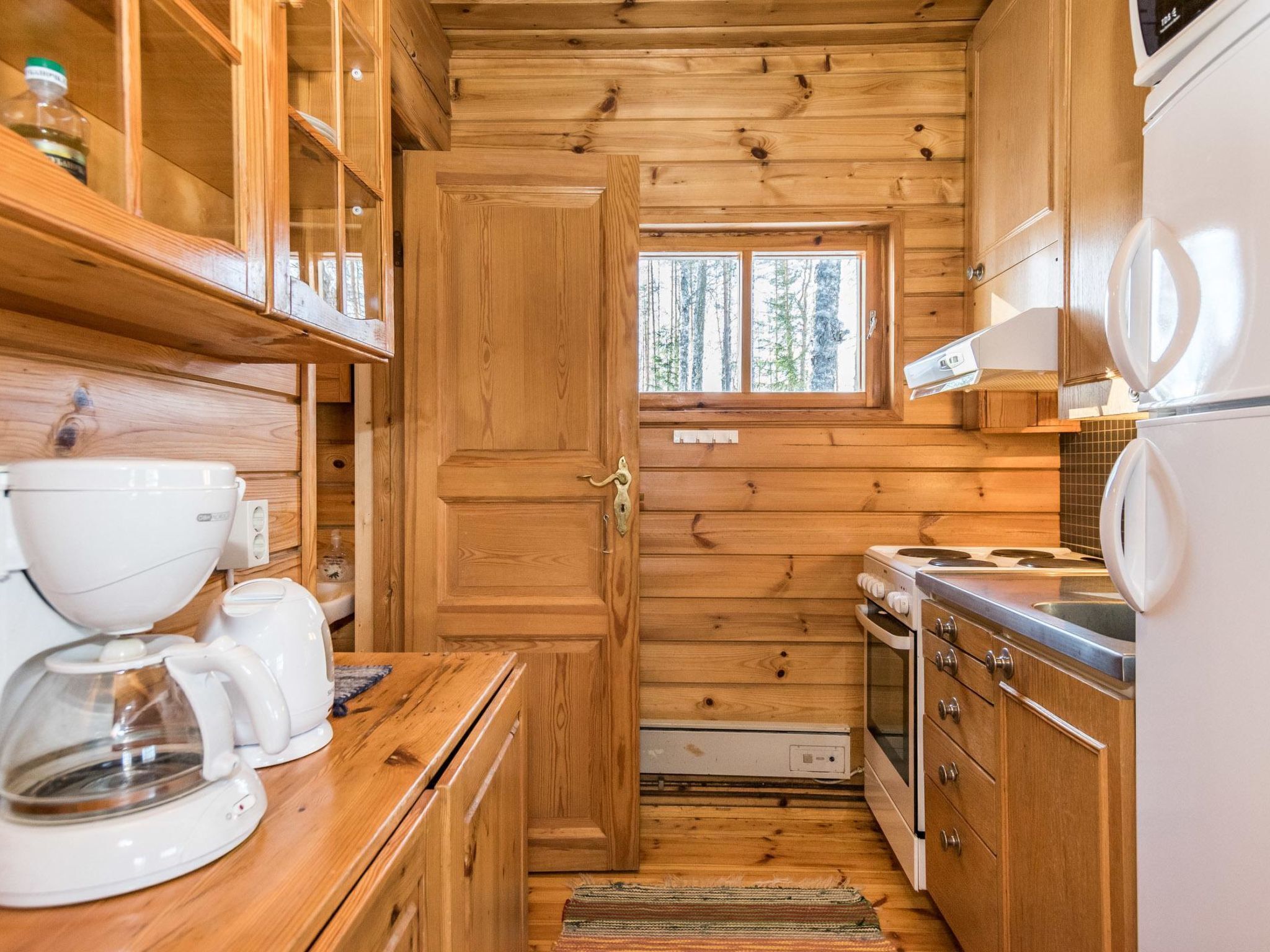 Een koelkast, een magnetron, kookgerei, borden en bestek