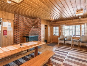 A wooden interior with a brick fireplace, wooden tables, and chairs. - Vacation home 2233. by Interhome (Savonlinna)