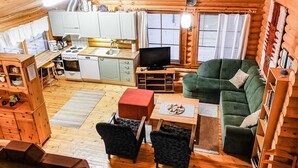 A cozy log cabin interior with a kitchen, dining area, and living room.