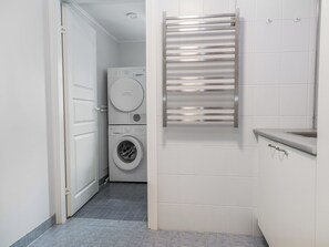 Un cuarto de lavado con lavadora, secadora y un perchero para toallas.